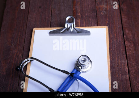 Appunti con stetoscopio blu su sfondo bianco. Salute Concetto di diagnostica. Foto Stock