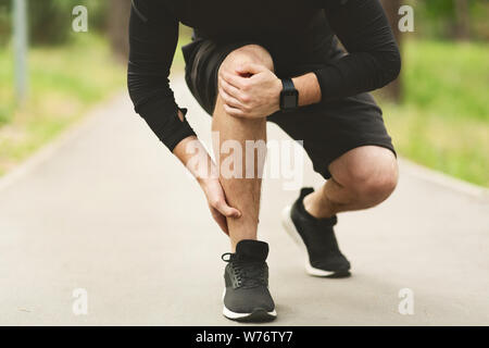 Maschio di runner è che soffrono di dolore alla caviglia su jogging Foto Stock