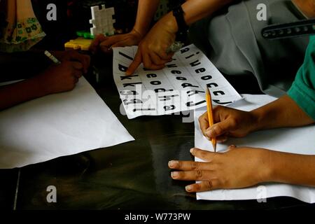 Bogor, West Java, Indonesia - Luglio 2019 : una immagine ravvicinata di elementare bambini processo di insegnamento con alfabeto e disegni in una classe di volontariato. Foto Stock