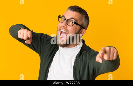 Allegro uomo barbuto felicemente indicando in telecamera Foto Stock