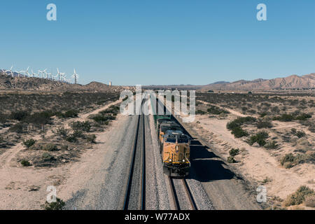 Un lungo treno merci si avvicina tra un vento-fattoria della turbina e il deserto al di fuori della città di Cabazon in Riverside County, California descrizione fisica: 1 Foto : Digital, file TIFF a colori. Note: titolo, data e parole chiave fornite dal fotografo.; Foto Stock