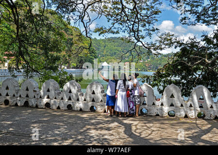 Kandy, Sri Lanka - Luglio 6, 2016: vista incorniciata da un gruppo di donne che prendono un selfie sul Lago Kandy shore Foto Stock