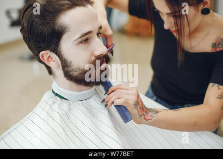 Elegante uomo seduto in una barberia Foto Stock