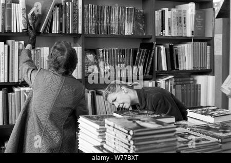 1970 shopping Inghilterra. Donne in una libreria, la gente che naviga selezionando libri affollato occupato Londra libri negozi 70s UK HOMER SYKES Foto Stock