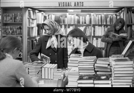 1970 shopping, donne in un negozio di libri gente che naviga selezionando libri affollato occupato Londra libreria anni 70 Regno Unito OMERO SYKES Foto Stock