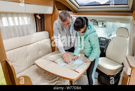 Le coppie in RV Camper guardando la mappa locale per il viaggio. Vacanza per la famiglia in viaggio, viaggio vacanza in camper, caravan auto vacanza. Foto Stock