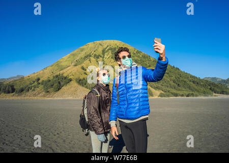 Giovane uomo e donna turisti fanno un selfie in bromo Tengger Semeru Parco nazionale sull'isola di Giava, in Indonesia. Essi godono di una magnifica vista sul Foto Stock