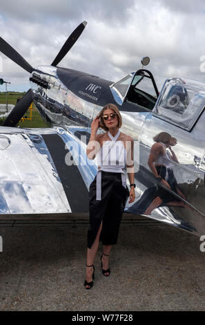 Rosamund Pike con un restaurato MK IX Spitfire a Goodwood aerodromo. IWC Schaffhausen argento Spitfire piloti Matt Jones e Steve Boultbee Brooks sta cercando di battere la MK IX Spitfire denominato 'Silver Spitfire" in tutto il mondo nella prima circumnavigazione del globo da parte di un piano di spitfire. Foto Stock