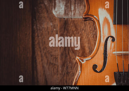 Close up di un violino shallow profondità di campo su uno sfondo di legno Foto Stock