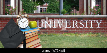 Una pila di libri di fronte all università per il concetto di istruzione Foto Stock