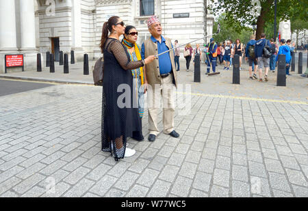 Londra, Inghilterra, Regno Unito. Famiglia indiana in Whitehall prendendo un gruppo selfie Foto Stock