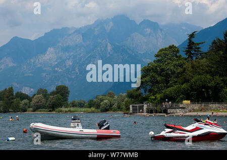 Il lago di Como, Italia - 21 Luglio 2019: fantastico paesaggio estivo con barche sul lago. Spiaggia Vicino a Colico nel lago di Como regione, Alpi, Italia. Alberi e Foto Stock