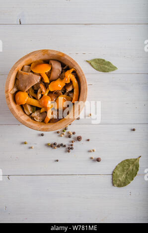 Decapare i funghi di utensili in legno su uno sfondo bianco Foto Stock
