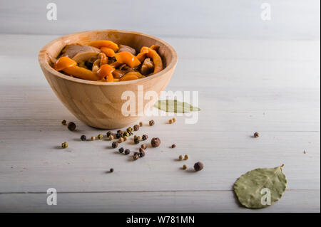 Decapare i funghi di utensili in legno su uno sfondo bianco Foto Stock