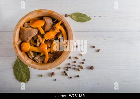 Decapare i funghi di utensili in legno su uno sfondo bianco Foto Stock