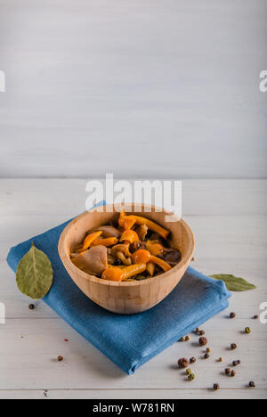Decapare i funghi di utensili in legno su uno sfondo bianco Foto Stock