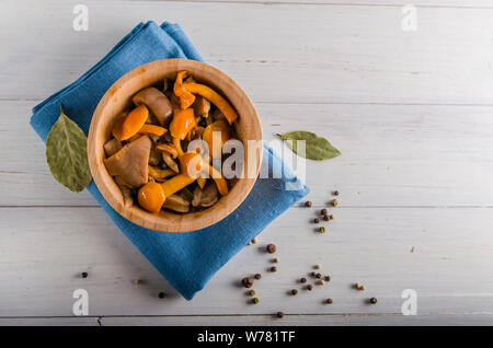 Decapare i funghi di utensili in legno su uno sfondo bianco Foto Stock