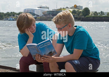 Gli adolescenti durante lo studio della lingua corsa nello studio della loro guida della città accanto al fiume Elba, Amburgo, Germania Foto Stock