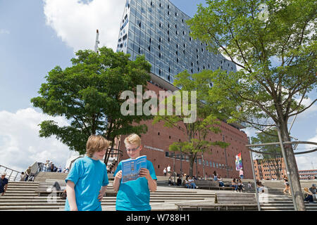 Gli adolescenti durante lo studio della lingua corsa nello studio della loro guida della città nella parte anteriore del Elbe Philharmonic Hall, Amburgo, Germania Foto Stock