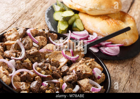 Gerusalemme gustose grigliate miste o meorav Yerushalmi servita con pita e sottaceti close-up su una piastra sul tavolo orizzontale. Foto Stock