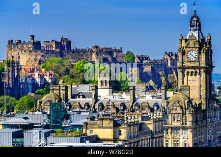 Il Castello di Edimburgo, che siede sulla roccia sopra la città e il Balmoral orologio in primo piano. Foto Stock