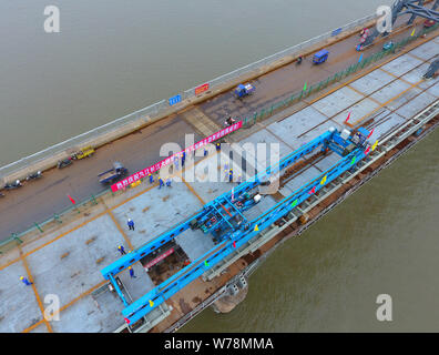 Lavoratori cinesi installare l'ultimo ponte in acciaio ponte presso il sito di un progetto di rinforzo di Jiujiang il Ponte sul Fiume Yangtze di Jiujiang in città, east mento Foto Stock