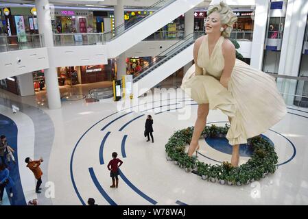 Un otto-metro-tall scultura della actrice americano e il modello Marilyn Monroe, congelati con il suo vestito che soffia su è in esposizione presso un centro commerciale per lo shopping di Dali Foto Stock