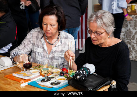 Johannesburg, Sud Africa - 24 Novembre 2012: Anziani amici di sesso femminile di mangiare e di bere e generalmente godendo di una giornata in un cibo e Fiera del Vino Foto Stock