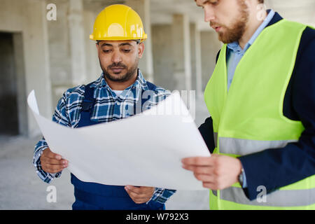 Due ingegneri discutere bozze che sia in attesa. Foto Stock