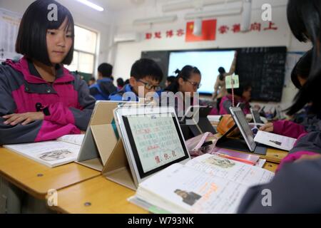 Gli alunni cinesi utilizzano Tablet PC come strumenti di apprendimento durante una lezione presso una scuola media nella Città di Zhengzhou, centrale cinese della provincia di Henan, 16 novembre 2017 Foto Stock