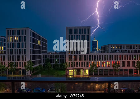 Un fulmine si blocca in un edificio per uffici di notte. Foto Stock