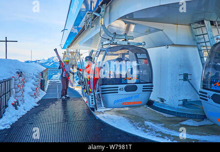 GOSAU, Austria - 26 febbraio 2019: gli sciatori lasciare la gondola sulla stazione superiore del moderno Panorama Jet Zwieselalm funivia, nel febbraio 26 in Gosau. Foto Stock
