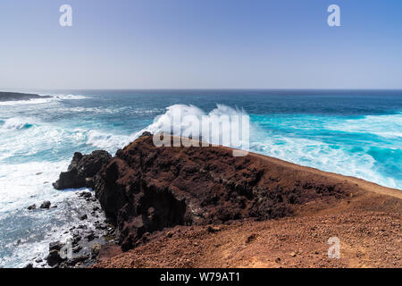 Spagna, Lanzarote, incredibile forte di onde che si infrangono sulle rocce creando enormi nubi di spume Foto Stock