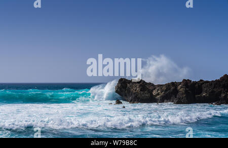 Spagna, Lanzarote, mare salato in Atlantico ruvida di onde che si infrangono a nere rocce laviche Foto Stock
