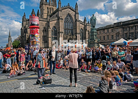 Street performer intrattenere i visitatori al Edinburgh Fringe Festival fuori la cattedrale di St Giles sul Royal Mile di Edimburgo, Scozia, Regno Unito. Foto Stock