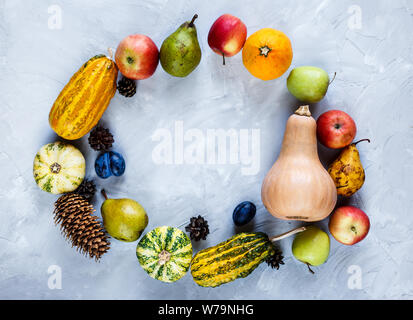 La Giornata del ringraziamento la composizione di frutta e verdura su sfondo grigio. Autumn harvest concetto. Zucche, pere, prugne, mele sul tavolo, vista dall'alto, Foto Stock