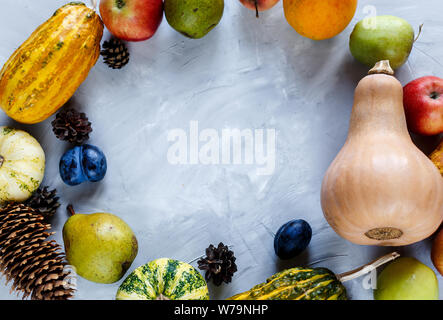 La Giornata del ringraziamento la composizione di frutta e verdura su sfondo grigio. Autumn harvest concetto. Zucche, pere, prugne, mele sul tavolo, vista dall'alto, Foto Stock