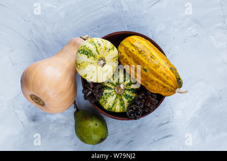 La Giornata del ringraziamento la composizione di frutta e verdura su sfondo grigio. Autumn harvest concetto. Zucche, pere, prugne, mele sul tavolo, vista dall'alto, Foto Stock