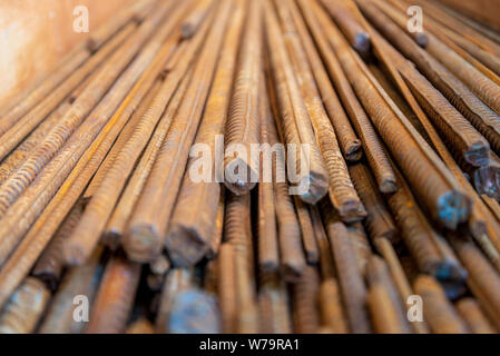 Close up selezionato vista focus pila di dritto vecchio arrugginito di alta sollecitazione di snervamento deformato in acciaio di rinforzo o barre di ferro. Foto Stock