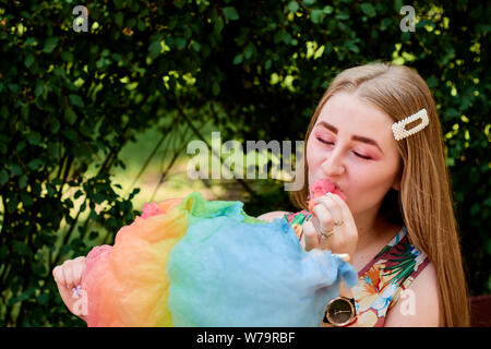 Felice gioiosa bella giovane donna con Candy Floss nel parco in estate. Foto Stock