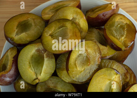 Fette di gustosa succose prugne su una piastra close up, susine vantaggi concetto. Foto Stock