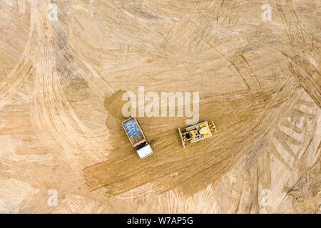 Vista dall'alto di via industriale bulldozer livellamento del terreno prima della costruzione della strada Foto Stock