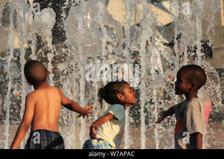 Bambini godendo interactive fontane ad acqua in estate Foto Stock