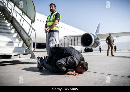 A Kabul, Afghanistan. 01 Ago, 2019. Un baci afgano il terreno all'aeroporto dopo aver lasciato una carta piano. 45 richiedenti asilo respinti sono stati deportati su un volo speciale in Afghanistan la capitale Kabul (zu dpa-storia: deportazione volo per l'Afghanistan) Credito: Michael Kappeler/dpa/Alamy Live News Foto Stock