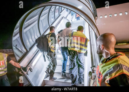 Leipzig, Germania. 01 Ago, 2019. Gli ufficiali di polizia accompagnano Afgani a Leipzig-Halle Aeroporto su una carta di aeromobili. 45 richiedenti asilo respinti sono stati deportati su un volo speciale in Afghanistan la capitale Kabul (zu dpa-storia: deportazione volo per l'Afghanistan) Credito: Michael Kappeler/dpa/Alamy Live News Foto Stock