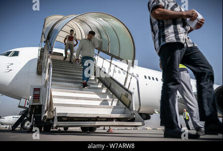 A Kabul, Afghanistan. 01 Ago, 2019. Gli afgani andare sulla passerella di collegamento da una carta piano. 45 richiedenti asilo respinti furono deportati sul volo speciale in Afghanistan la capitale Kabul. (Attenzione: le facce dei deportati sono irriconoscibili per motivi di protezione della personalità. Un logo della compagnia aerea che ha effettuato il volo di espulsione a destra della passerella, è stato reso irriconoscibile da Frontex come una condizione; circa il DPA-storia: deportazione volo per l'Afghanistan) Credito: Michael Kappeler/dpa/Alamy Live News Foto Stock