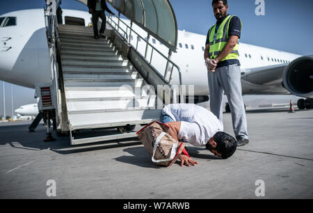 A Kabul, Afghanistan. 01 Ago, 2019. Un baci afgano il terreno all'aeroporto dopo aver lasciato una carta piano. 45 richiedenti asilo respinti furono deportati sul volo speciale in Afghanistan la capitale Kabul. (Attenzione: un logo della compagnia aerea che ha eseguito la deportazione di volo, a destra della passerella, sopra le finestre, è stato reso irriconoscibile da Frontex come una condizione; circa il DPA-storia: deportazione volo per l'Afghanistan) Credito: Michael Kappeler/dpa/Alamy Live News Foto Stock