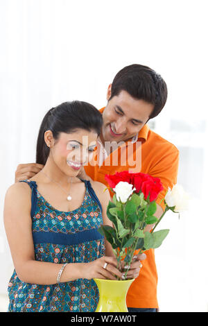 Young man putting on necklace around his wife neck Stock Photo