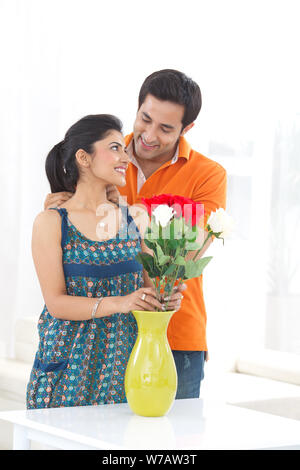 Young man putting on necklace around his wife neck Stock Photo