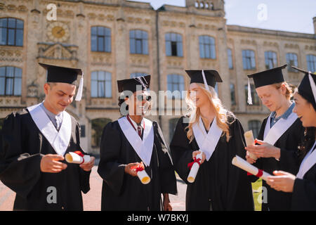 Allegro neodiplomati felice avendo i loro diplomi. Foto Stock